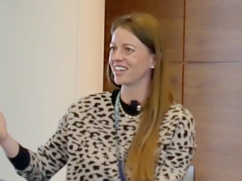 Natalie Levy in a leopard sweater giving the keynote at the Women Who Fund Summit at the University of Michigan