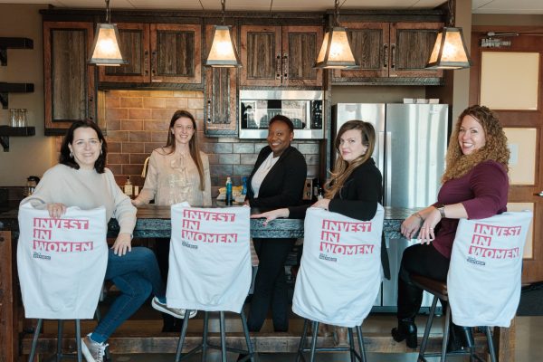 The She’s Independent team at the office, with Invest in Women sweatshirts on the stools